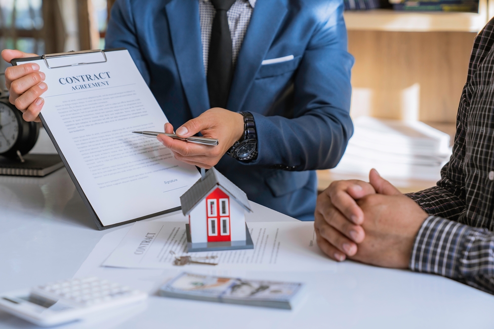 A real estate agent and client reviewing a contract
