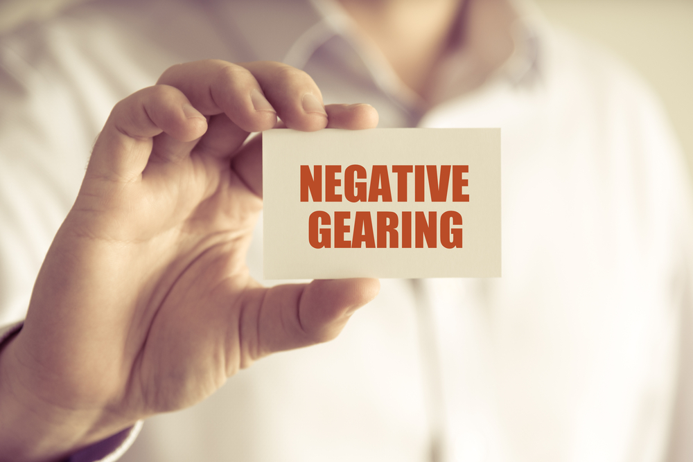 Close up On Businessman Holding A Card That Reads "Negative Gearing"