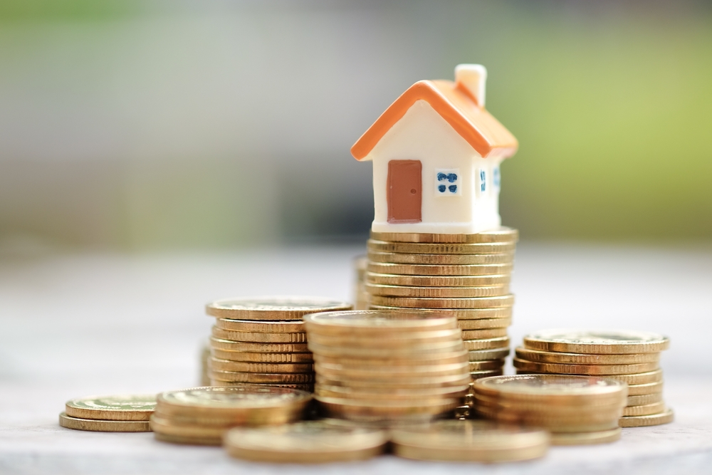 Mini House On Stack Of Coins: Property Investment