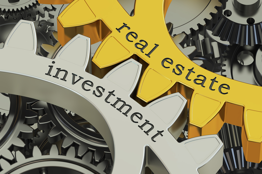 3D rendering of gold and silver gears with the words real estate investment
